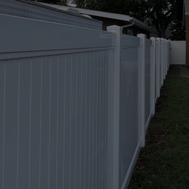 White fence near blue house and forest